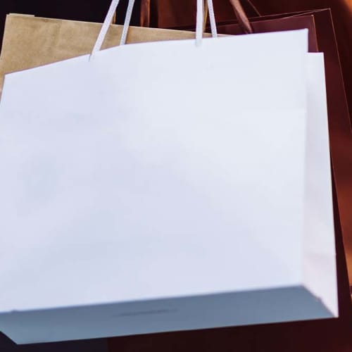 Man sitting on a bench with shopping bags near Broadleigh Lofts in Columbus, Ohio
