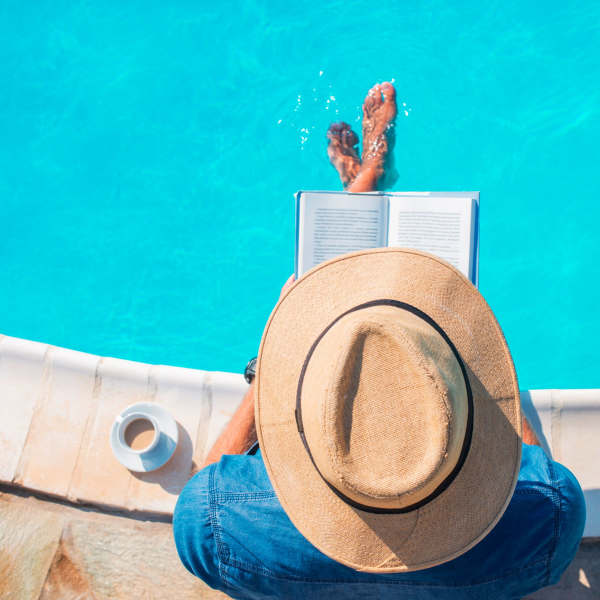 A resident reads a book by the pool at Promenade Pointe, Norfolk, Virginia