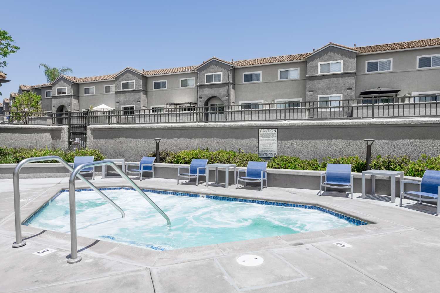 Seats near the community spa at Madrid Apartments in Mission Viejo, California
