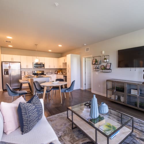 A furnished living room and open kitchen at Indigo Champions Ridge in Davenport, Florida