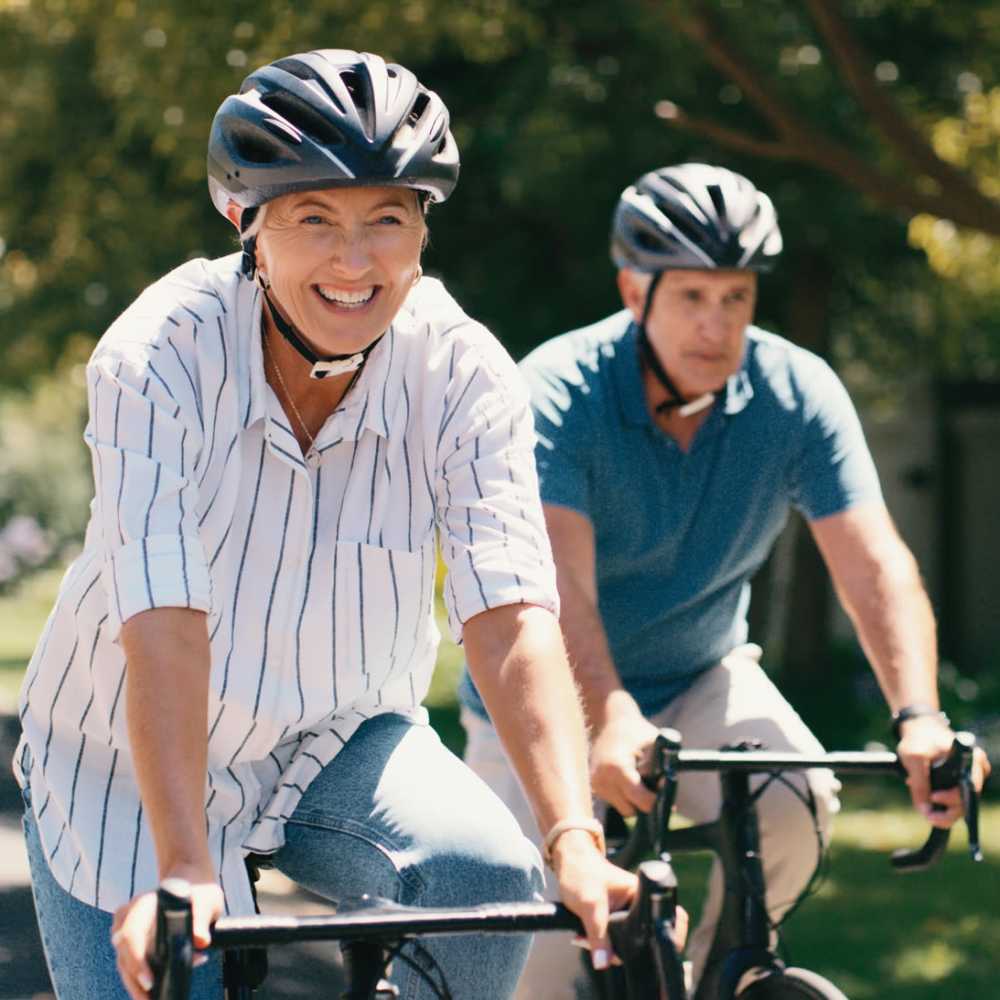 Resident couple riding bike in a park near Rolling Brook Apartments in Algonac, Michigan