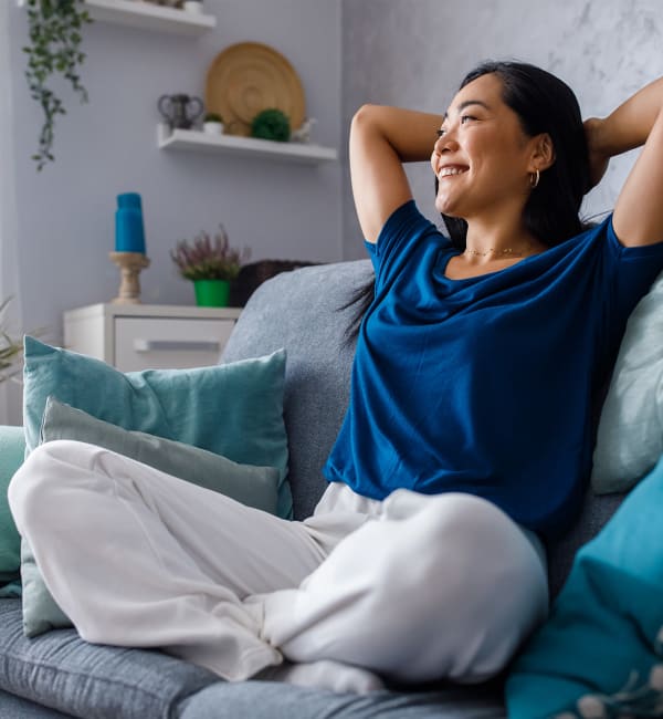 A woman relaxing on her couch in the living room at Mode at Hyattsville in Hyattsville, Maryland at Mode at Hyattsville in Hyattsville, Maryland