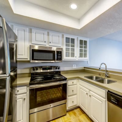 Modern kitchen with stainless-steel appliances in a model home at Sofi Irvine in Irvine, California