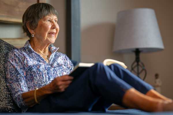 Residents reading in her room at Touchmark on South Hill in Spokane, Washington chatting as they walk down the hallway