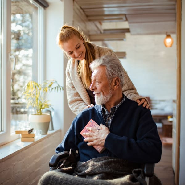 Caregiver and resident looking out of a window at Monte Vista Village in Lemon Grove, California