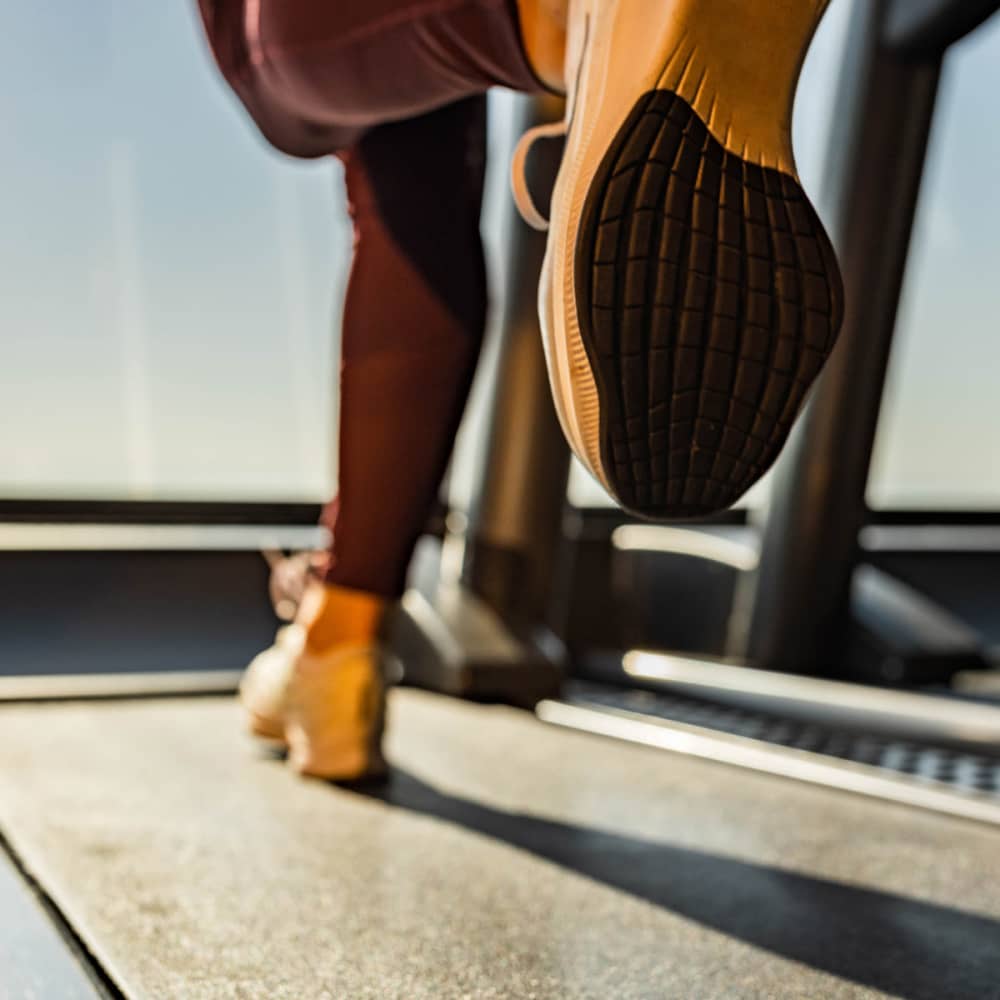 A resident exercising in the community fitness center at The Heyward Apartments in Corinth, Texas
