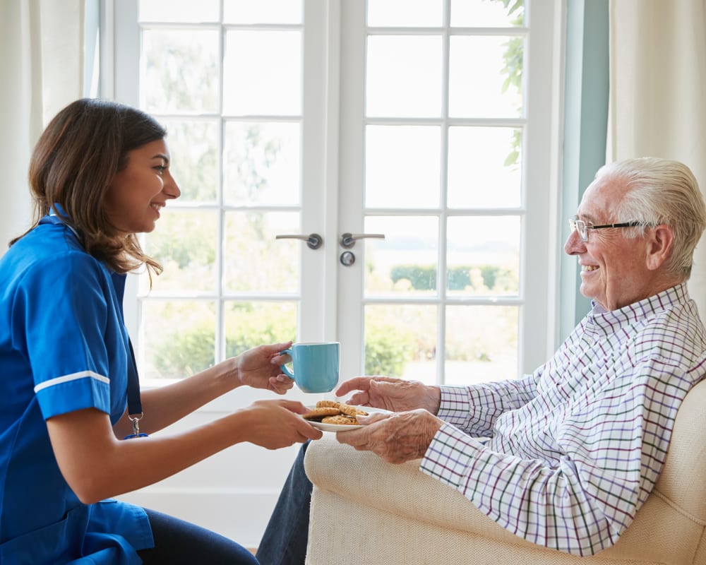 Staff member visits resident in his assisted living apartment at Prairie Hills Independence in Independence, Iowa.