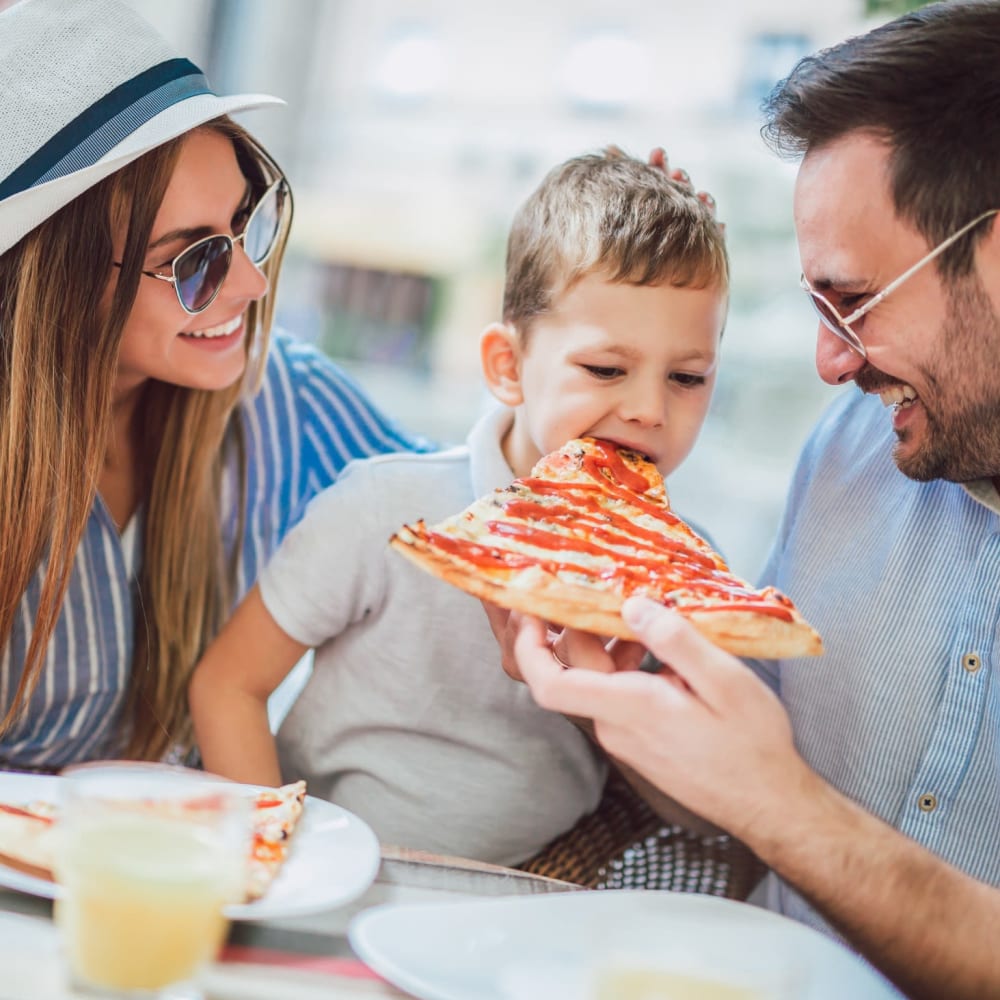 Couple with their son eating pizza at The Presidio in Pensacola, Florida