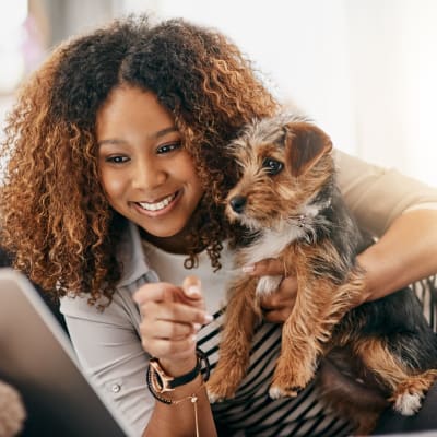 A resident holding a small dog in a home at Westcott Hill in Joint Base Lewis McChord, Washington