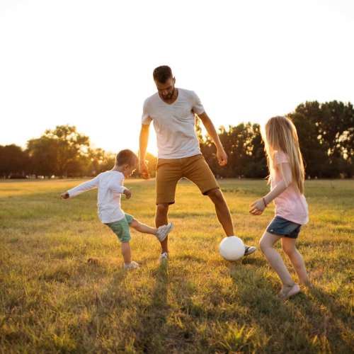 Resident playing football with his kids in a nearby playground at Waldorf, Maryland near Smallwood Gardens