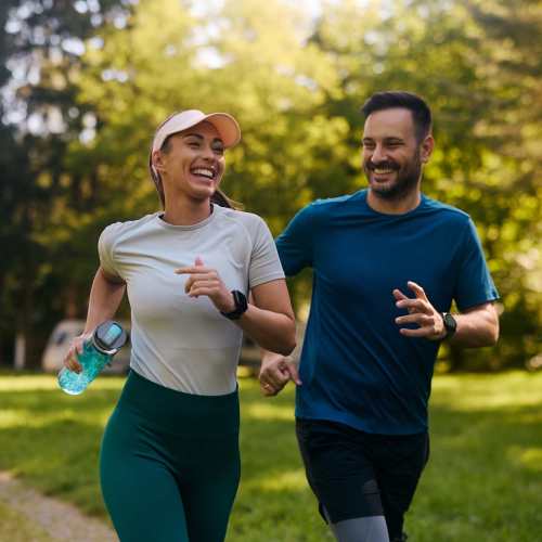 Happy residents out for a jog at a park near The Marke Apartment Homes in Santa Ana, California