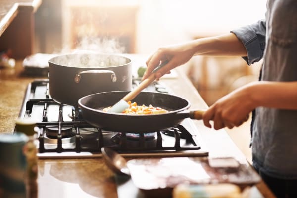 Resident cooking in a fully equipped kitchen at McNaughten Plaza in Columbus, Ohio