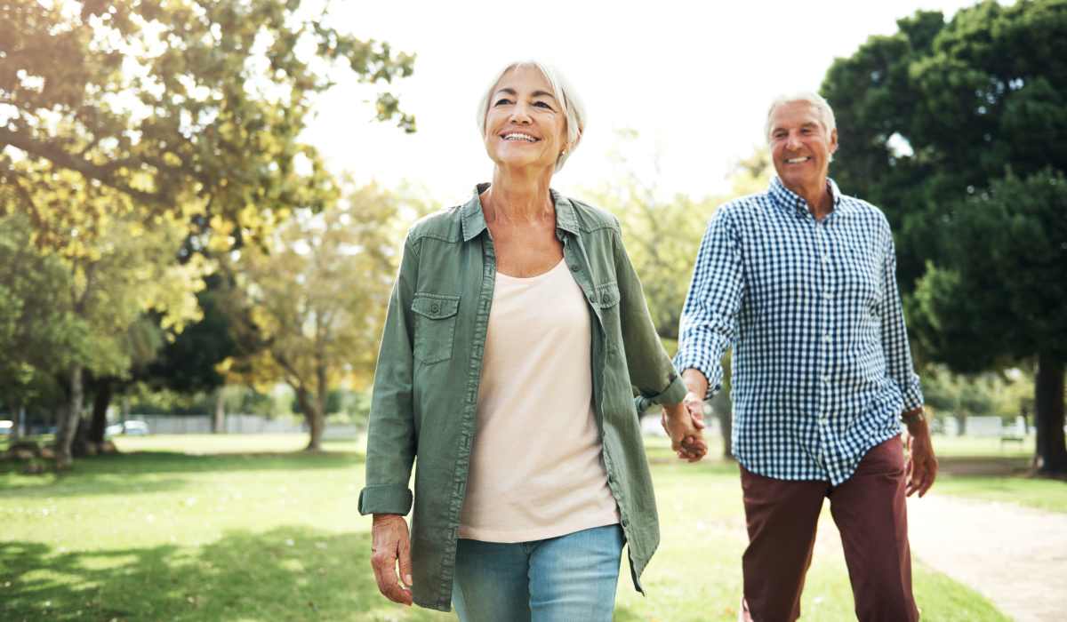 A couple holding hands together and walking in a park near The Windermere in Littleton, Colorado