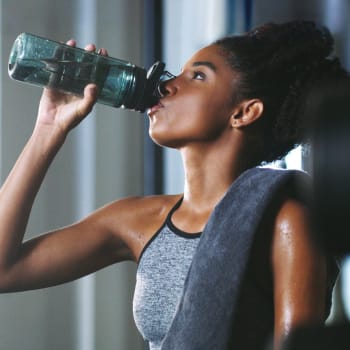 A women drinking water in the fitness center at Cypress Creek at Reed Road in Houston, Texas