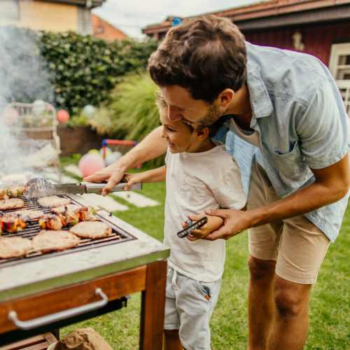 Resident with his son grilling at the BBQ covered picnic area at Willow Creek Villas in Sparks, Nevada