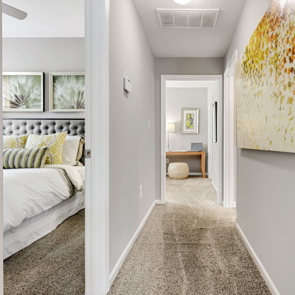 An apartment hallway leading to two bedrooms at The Courts of Avalon in Pikesville, Maryland