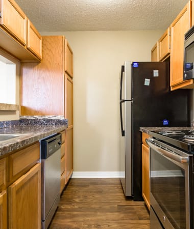 Model kitchen with stainless-steel appliances, granite countertops, and hardwood floor at North Pointe Apartments