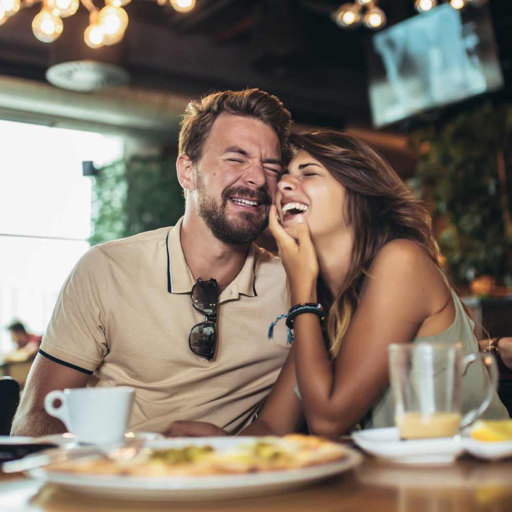 Couple laughing in a restaurant near Pine Tree Apartments in Winston, Oregon