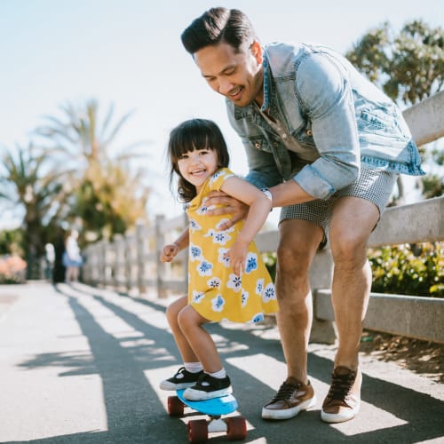 A father teaching his daughter to skateboard at Eucalyptus Ridge in Lakeside, California