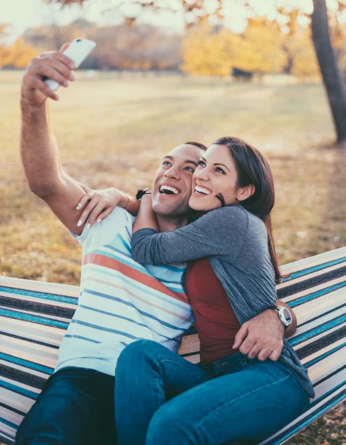 Student couple with their arms clicking a selfie near Brookside Downtown in Columbia, Missouri
