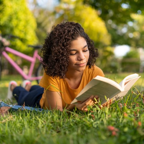 Resident reading in a park near Towne Centre Apartments in Lathrop, California