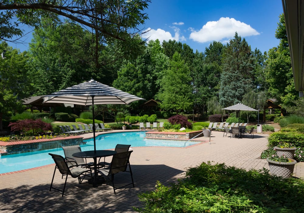 Lush mature trees providing shade at the resort-style swimming pool area at The Vinings at Newnan Lakes in Newnan, Georgia