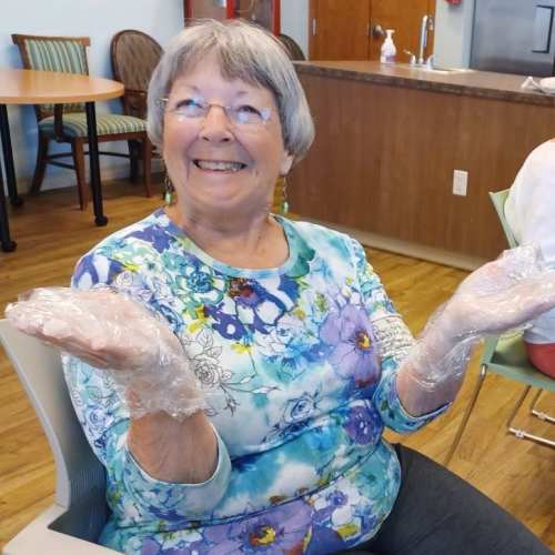 A resident receiving a wrapped gift at The Oxford Grand Assisted Living & Memory Care in Wichita, Kansas