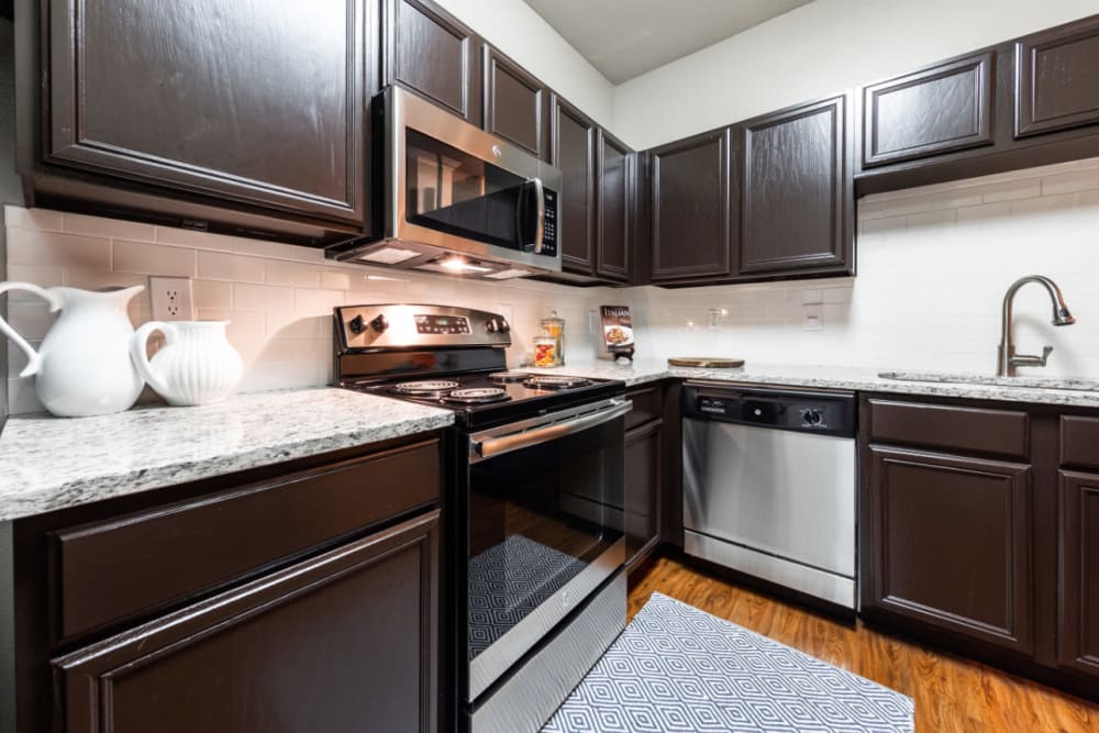 Kitchen with wood style flooring at Marquis at Ladera Vista in Austin, Texas