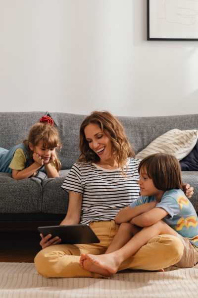 Woman with her kids in a living room at Sand Pebble and Spanish Oaks in Sparks, Nevada