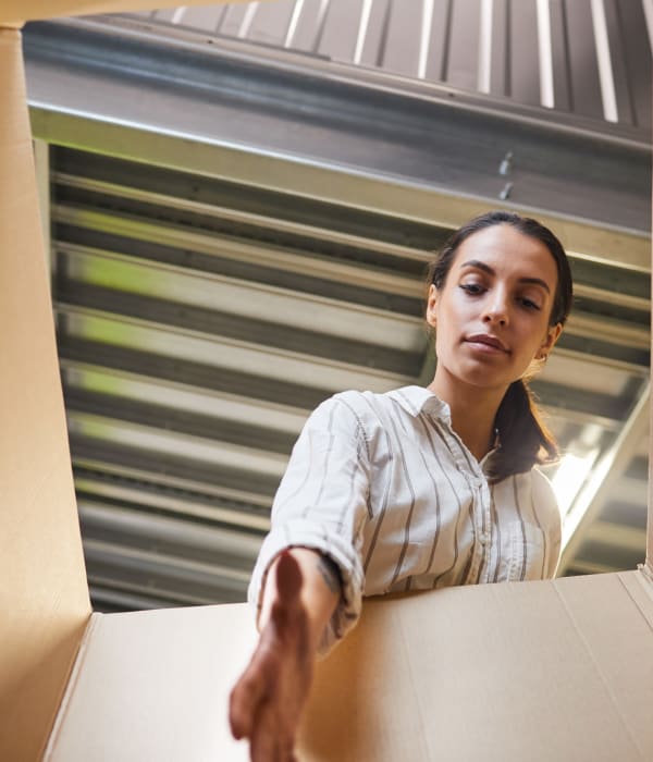 A woman peering into a box in her unit at Key Storage in San Antonio, Texas