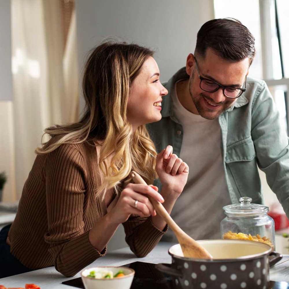 Couple cooking in kitchen at Westbury Apartments in Wayland, Michigan
