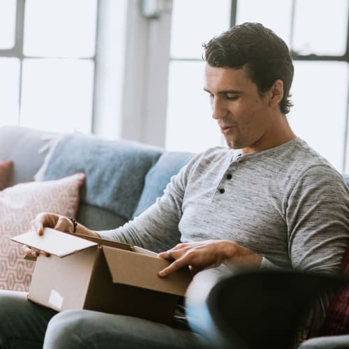 A resident looking through contents of a box in a home at Bayview Hills in San Diego, California