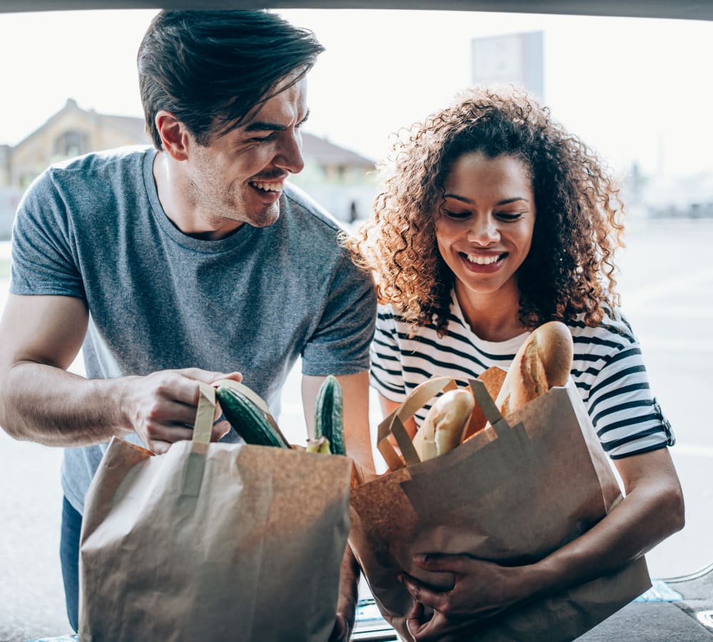 A woman and a man grabbing grocery bags from their car at Renaissance at Galleria in Hoover, Alabama