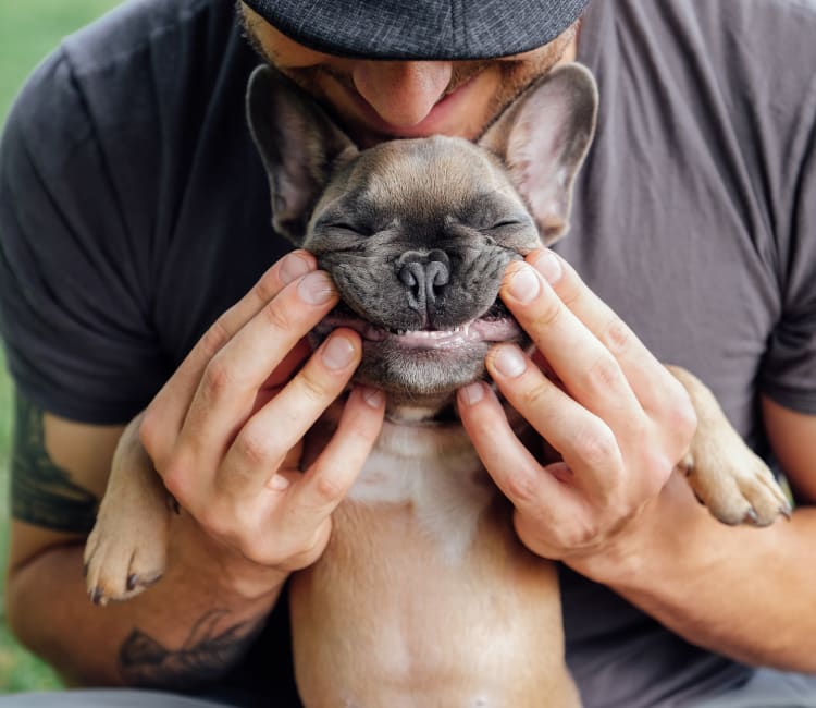 Resident and his puppy posing for a photo outside their new home at Sofi Belmont Hills in Belmont, California