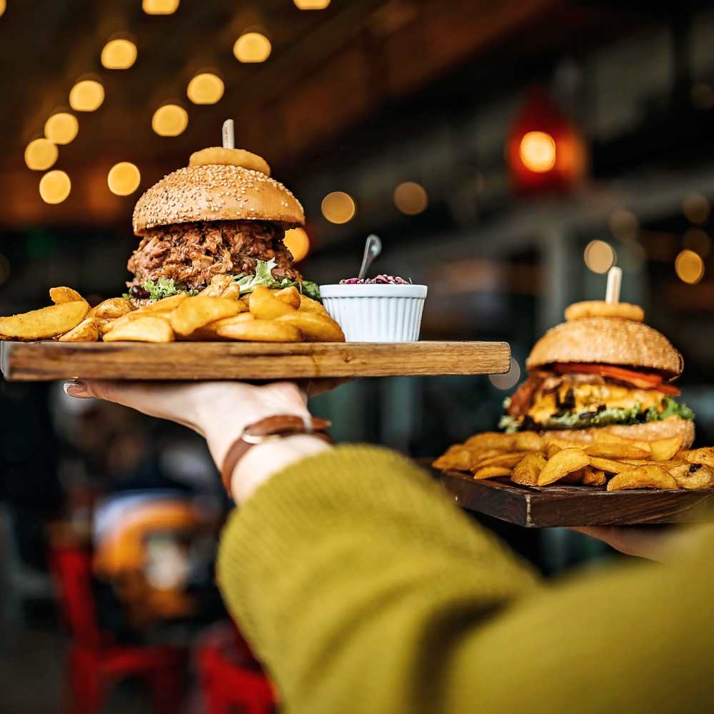 Wooden platter with burgers and fries at Avia Lofts at Maple Road in Amherst, New York