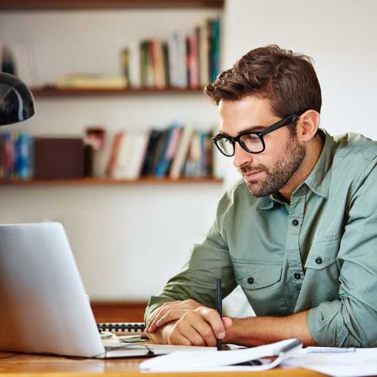 Resident using online rental portal in the living room at Huntington Reef in Huntington Beach, California