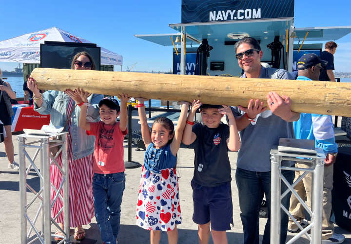 Children playing a game where they life a large log over there heads at the San Deigo Fleet Week