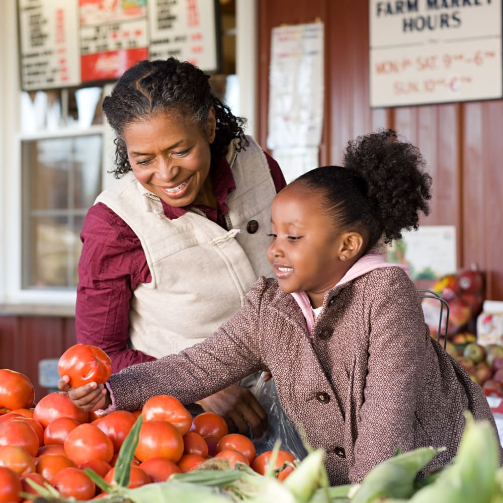 Resident and her granddaughter shopping for fresh produce at a market near our Sonoma Mission community at Mission Rock at Sonoma in Sonoma, California