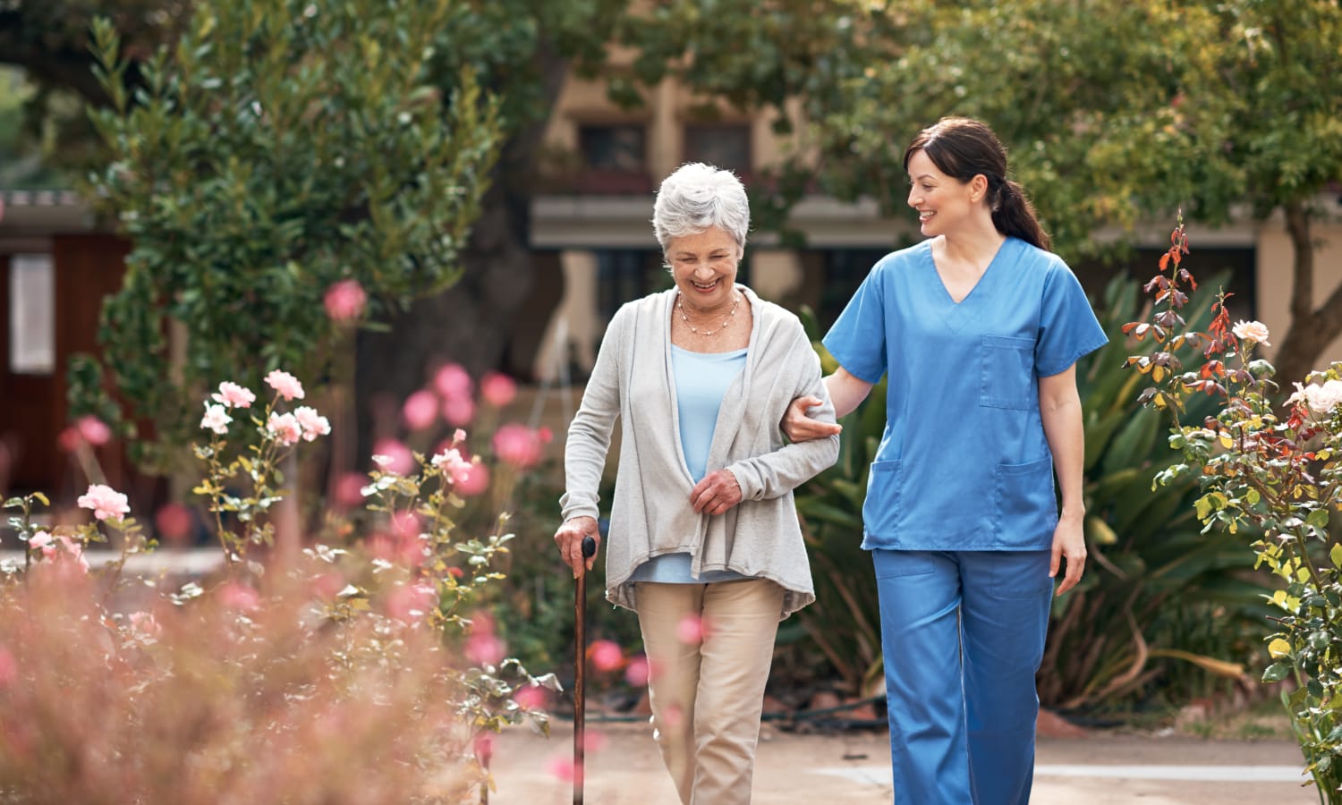 Resident and a caretaker walking through the gardens at The Birches of Lehigh Valley in Easton, Pennsylvania