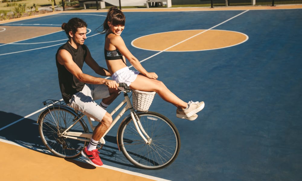 Students riding a bike on a sport court near Campus Prime in Syracuse, New York