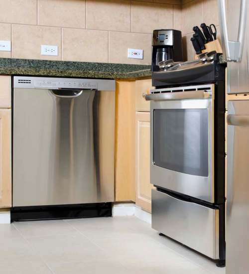 Kitchen with wood cabinets and steel appliances at Windsor Gardens Apartments in Rochester, New York
