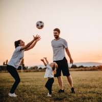 Parents playing with child near Woodlawn Lofts in Pittsburgh, Pennsylvania
