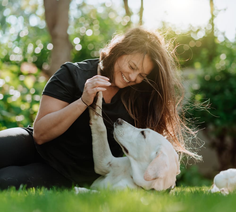 Woman playing with her dog in a park near Graham Residential in Miami Lakes, Florida