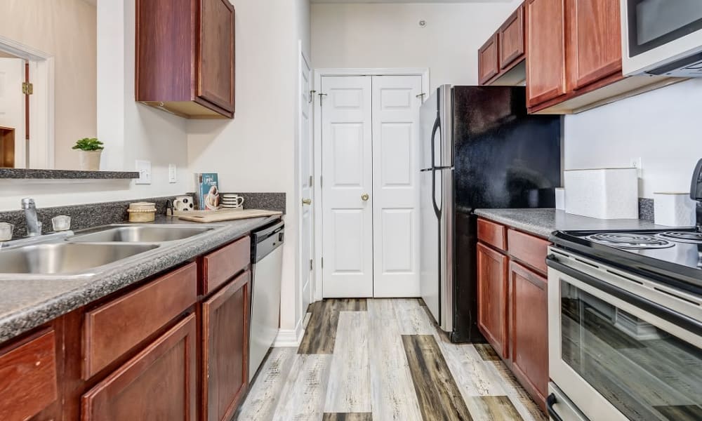 Kitchen with stainless-steel appliances and dining area at Harborside Apartment Homes in Slidell, Louisiana