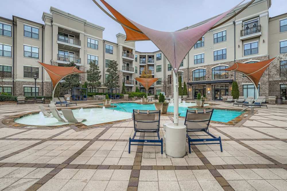Bask in the sun beside the sparkling water pool, surrounded by lush landscaping and modern architecture, perfect for relaxing and entertaining at 2370 Main at Sugarloaf in Duluth, Georgia
