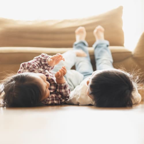 Two children laying on the floor with their feet on a couch at Gela Point in Virginia Beach, Virginia