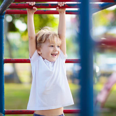 A child playing on monkey bars at a playground at Heartwood in Joint Base Lewis McChord, Washington