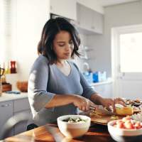 Resident chopping vegetables in her kitchen at Arbors at the Reservoir in Ridgeland, Mississippi, 