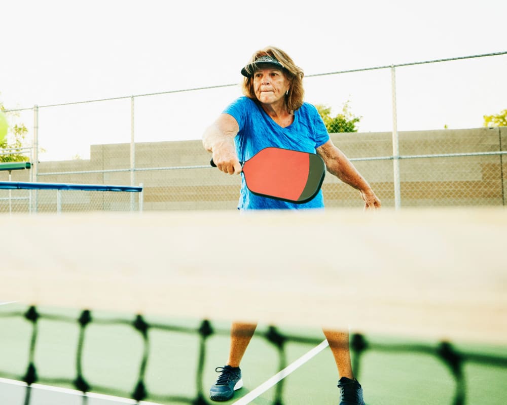 A woman playing pickleball at Flower Mound Assisted Living in Flower Mound, Texas