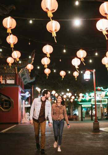 Resident couple walking in a lit pathway near Magnolia Crossing and Bell Ridge II in Pace, Florida